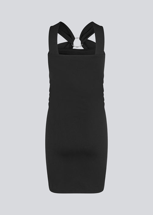 Short fitted black dress in an elastic material. EmiliaMD dress has a cool detailed metal ring at the chest and wide straps.