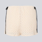 Cute shorts in a soft lace material in light beige/white. EmiliaMD lace shorts have lining and elastic at the waist. The shorts have two black bows on hips as a cool contrast to the light beige.