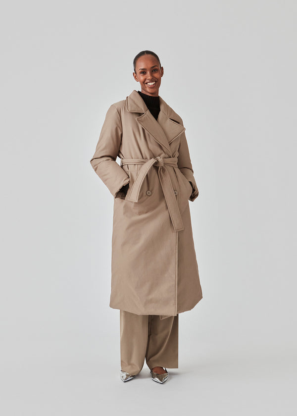 Jacket in a trench coat look with outer layer made from a cotton and nylon blend. EsmeMD jacket is double-breasted with a wide collar and lapel along with a wide tie belt at the waist. The model is 175 cm and wears a size S/36.