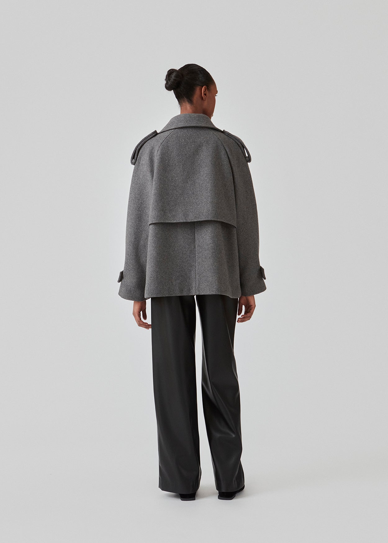 Cropped double-breasted wool coat with hidden buttons. EsmundMD jacket, in the colot Dark Grey Melange, has classic coat details with raglan sleeves and an high yoke at the back. Lined. The model is 175 cm and wears a size S/36.