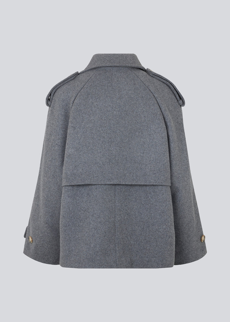 Cropped double-breasted wool coat with hidden buttons. EsmundMD jacket, in the colot Dark Grey Melange, has classic coat details with raglan sleeves and an high yoke at the back. Lined. The model is 175 cm and wears a size S/36.