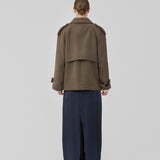 Cropped double-breasted wool coat in a brown color with hidden buttons. EsmundMD jacket has classic coat details with raglan sleeves and an high yoke at the back. Lined. The model is 175 cm and wears a size S/36.
