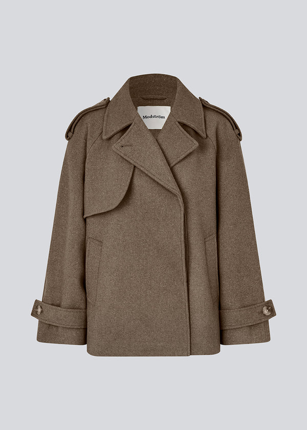 Cropped double-breasted wool coat in a brown color with hidden buttons. EsmundMD jacket has classic coat details with raglan sleeves and an high yoke at the back. Lined. The model is 175 cm and wears a size S/36.