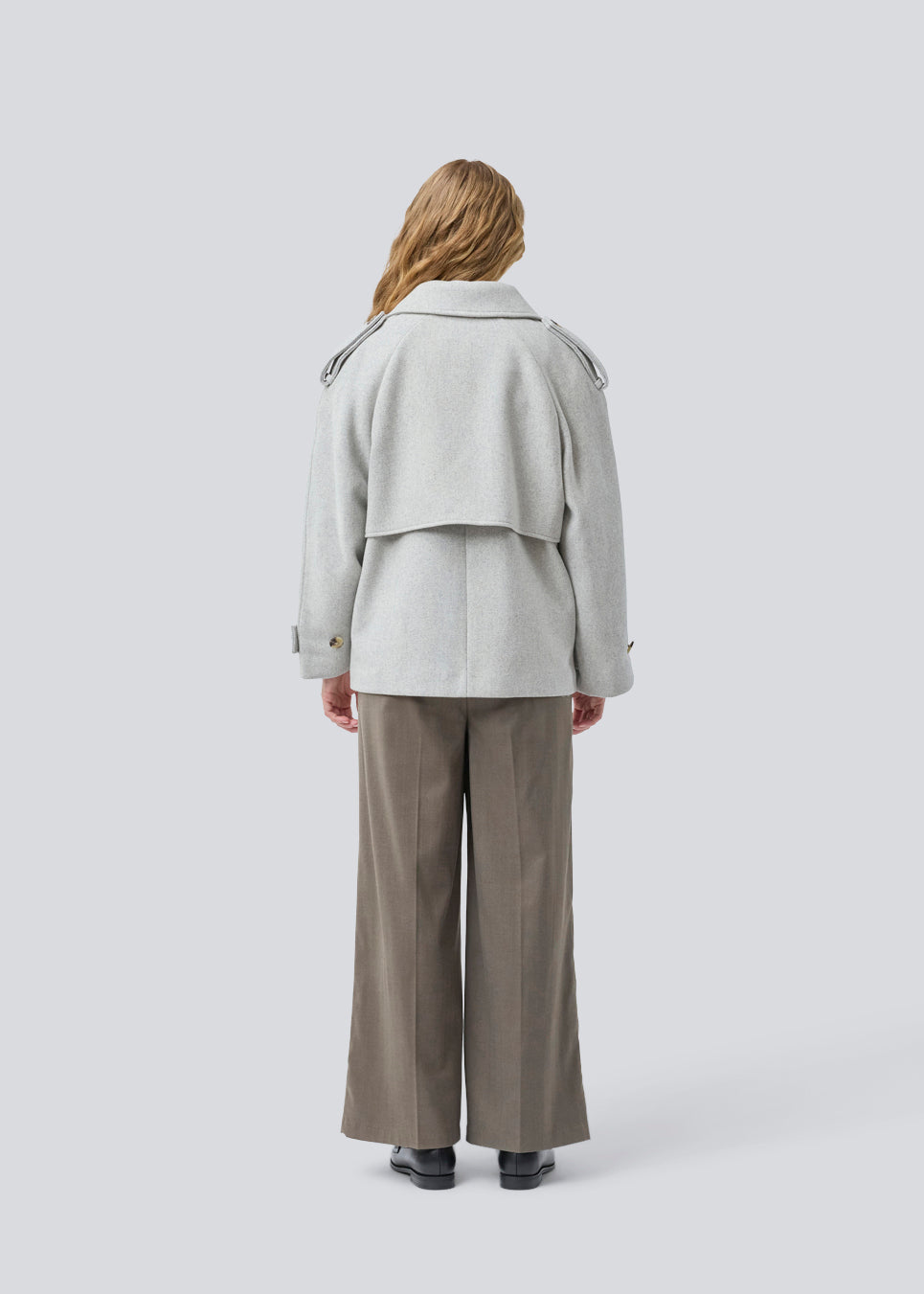 Cropped double-breasted wool coat in light grey with hidden buttons. EsmundMD jacket has classic coat details with raglan sleeves and an high yoke at the back. Lined. The model is 175 cm and wears a size S/36.