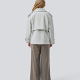 Cropped double-breasted wool coat in light grey with hidden buttons. EsmundMD jacket has classic coat details with raglan sleeves and an high yoke at the back. Lined. The model is 175 cm and wears a size S/36.