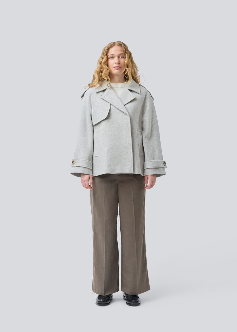 Cropped double-breasted wool coat in light grey with hidden buttons. EsmundMD jacket has classic coat details with raglan sleeves and an high yoke at the back. Lined. The model is 175 cm and wears a size S/36.