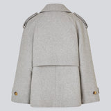 Cropped double-breasted wool coat in light grey with hidden buttons. EsmundMD jacket has classic coat details with raglan sleeves and an high yoke at the back. Lined. The model is 175 cm and wears a size S/36.