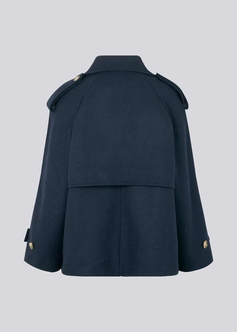 Cropped double-breasted wool coat with hidden buttons. EsmundMD jacket, in the colot Navy Sky, has classic coat details with raglan sleeves and an high yoke at the back. Lined. The model is 175 cm and wears a size S/36.