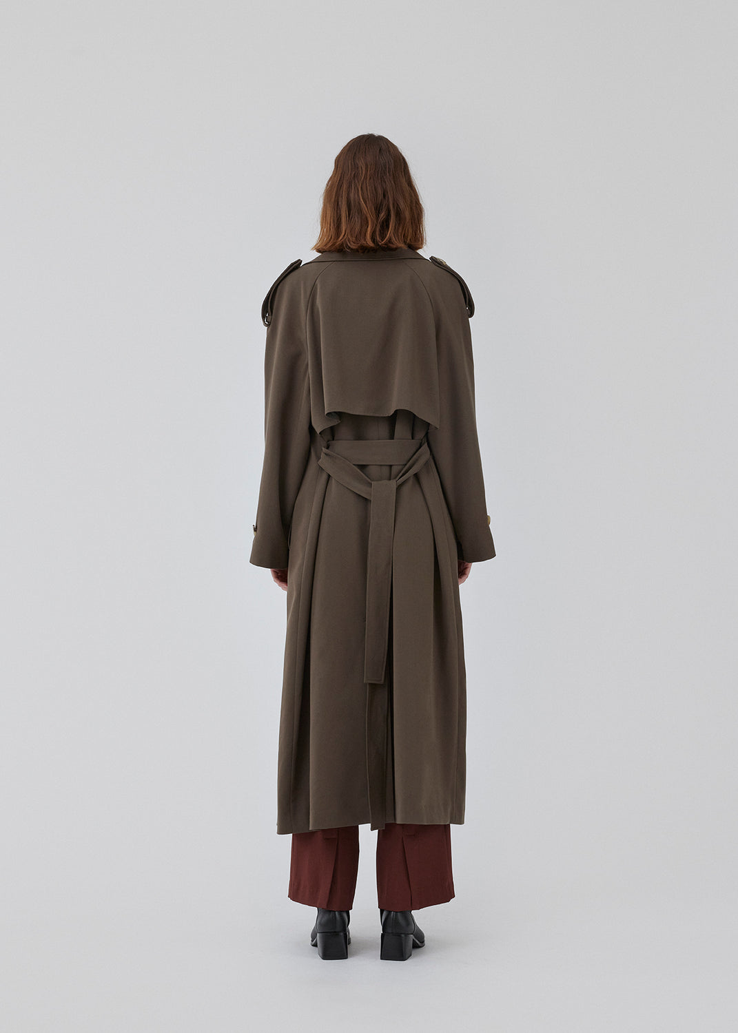 Oversized double-breasted trench coat in dark brown with tie belt at the waist. EvieMD jacket has dropped shoulders and long, wide sleeves. Lined