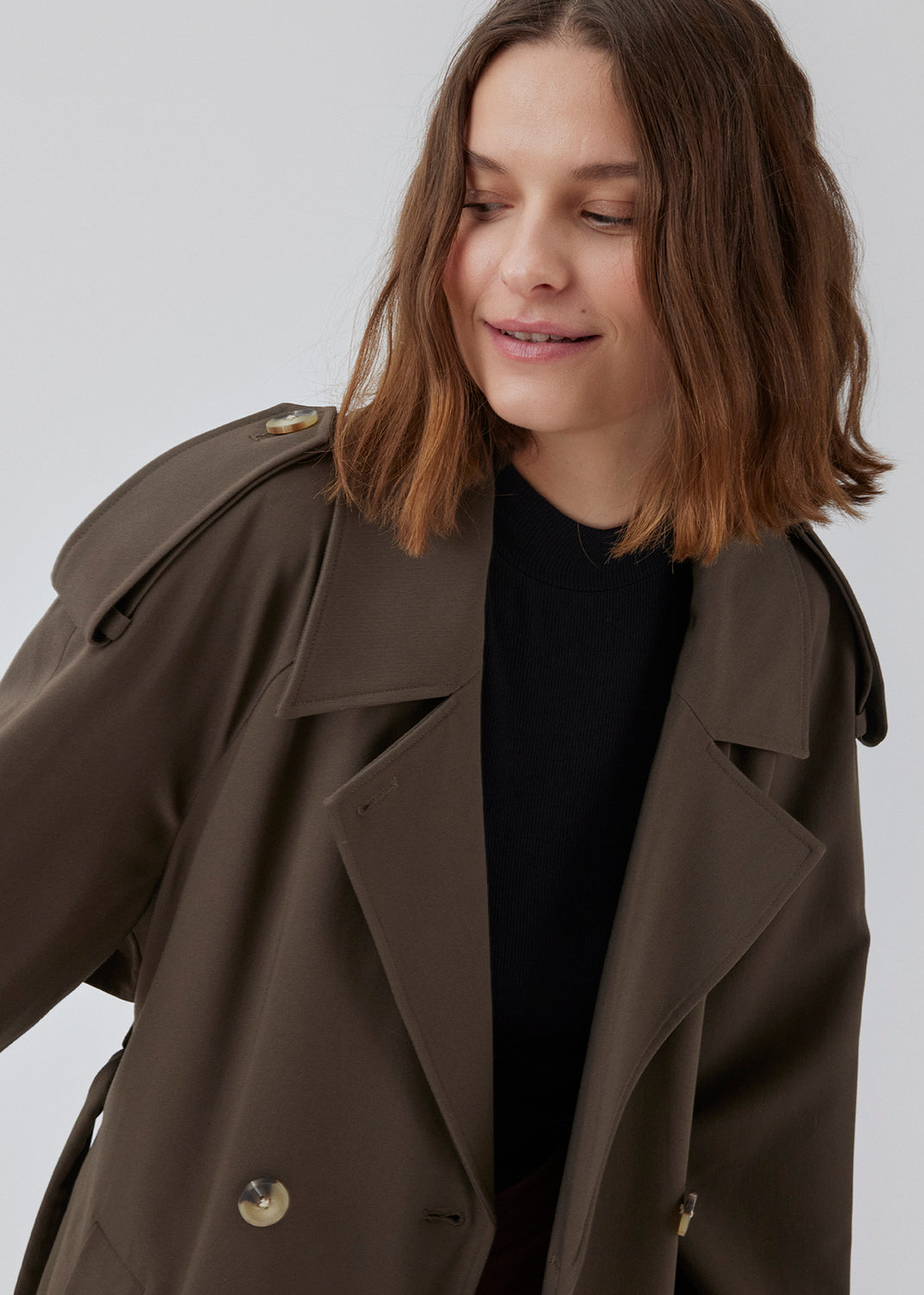 Oversized double-breasted trench coat in dark brown with tie belt at the waist. EvieMD jacket has dropped shoulders and long, wide sleeves. Lined