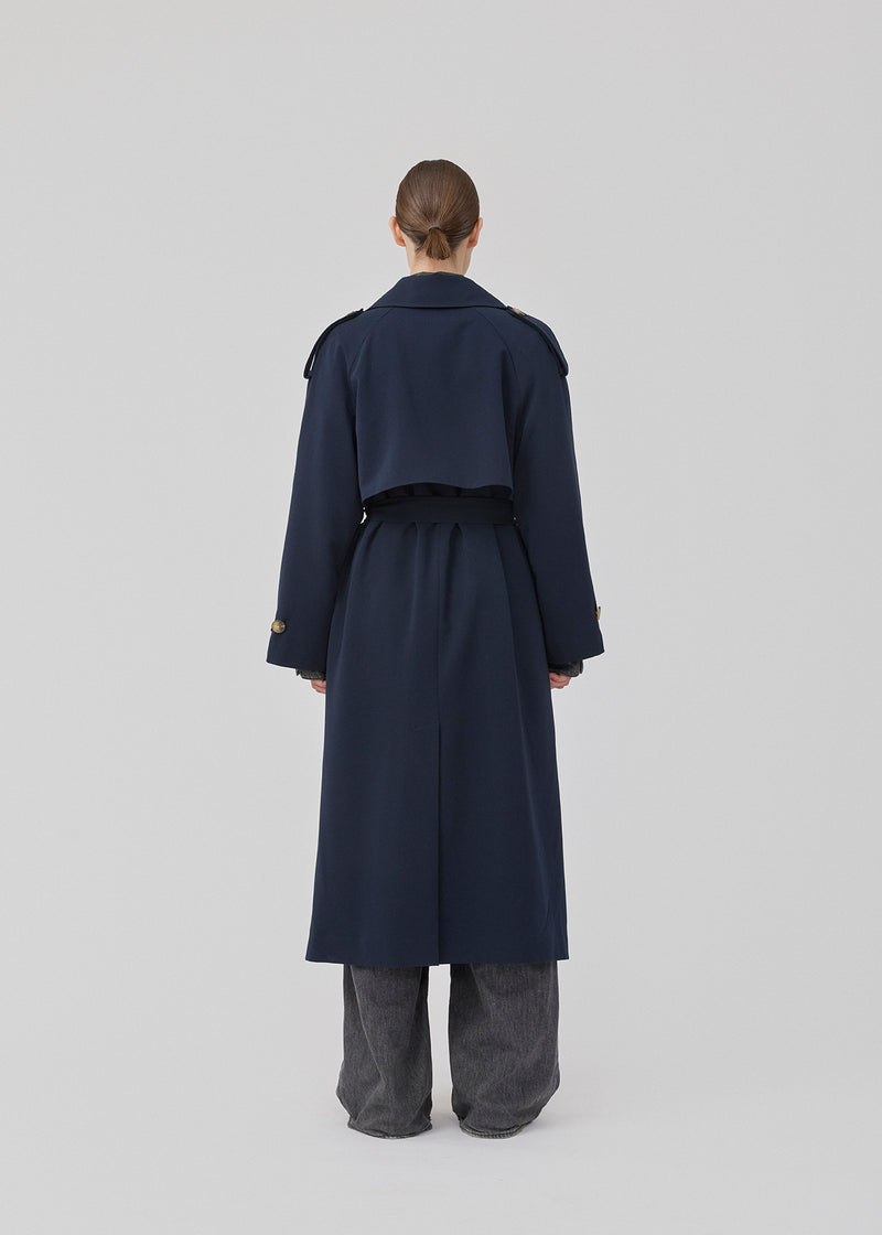 Oversized double-breasted trench coat with tie belt at the waist. EvieMD jacket has dropped shoulders and long, wide sleeves. Lined. The model is 175 cm and wears a size S/36.