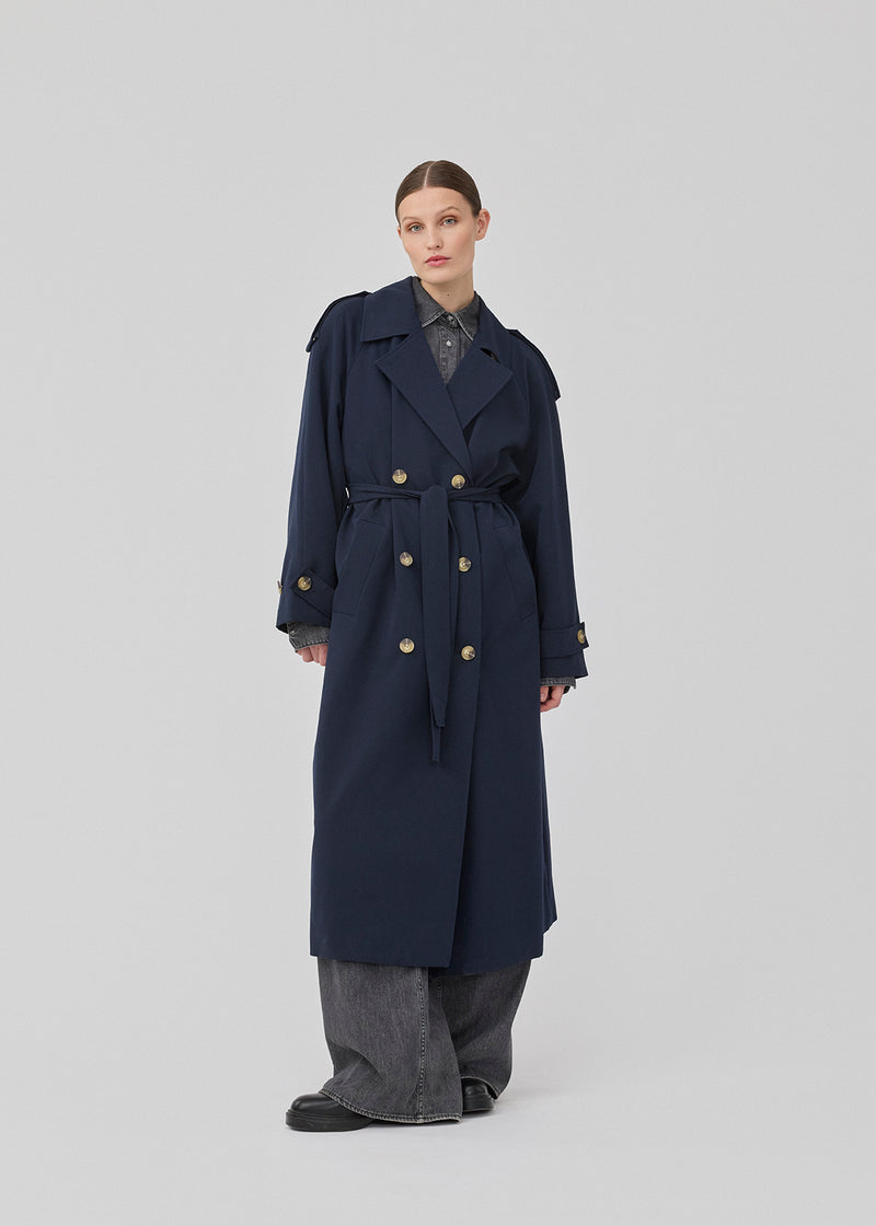 Oversized double-breasted trench coat with tie belt at the waist. EvieMD jacket has dropped shoulders and long, wide sleeves. Lined. The model is 175 cm and wears a size S/36.