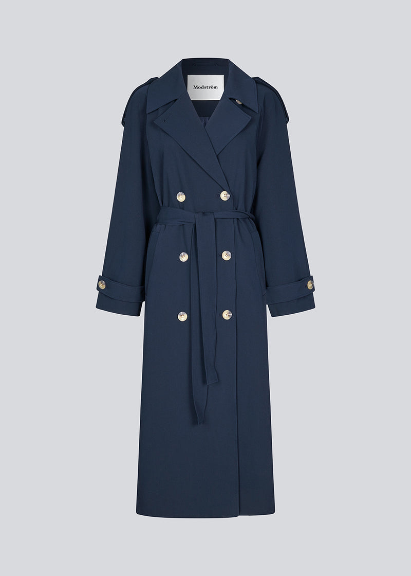 Oversized double-breasted trench coat with tie belt at the waist. EvieMD jacket has dropped shoulders and long, wide sleeves. Lined. The model is 175 cm and wears a size S/36.