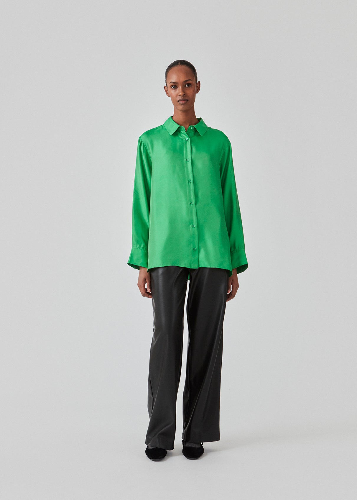 Green shirt in a silk quality with a loose shape. FableMD shirt has a collar and button closure in front, long voluminous sleeves and a wide cuff. The model is 175 cm and wears a size S/36.