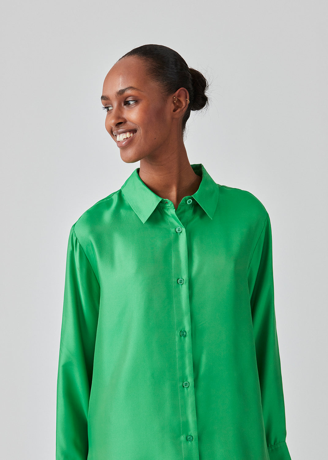 Green shirt in a silk quality with a loose shape. FableMD shirt has a collar and button closure in front, long voluminous sleeves and a wide cuff. The model is 175 cm and wears a size S/36.