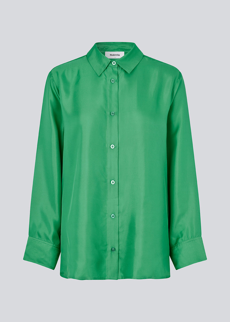 Green shirt in a silk quality with a loose shape. FableMD shirt has a collar and button closure in front, long voluminous sleeves and a wide cuff. The model is 175 cm and wears a size S/36.
