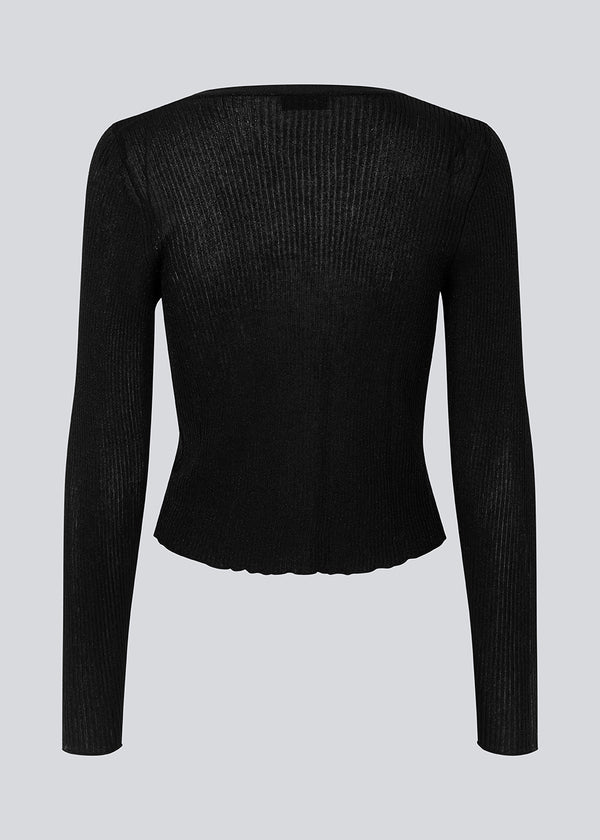 Black cardigan in an airy knit with a slightly see-through look. FaddieMD cardigan is a bit cropped, has long sleeves and tie band closure in front.