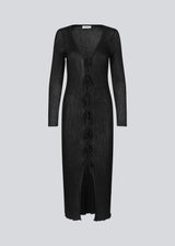 Long black dress in an airy knit with a slightly see-through design. FaddieMD dress has a v-neckline, long sleeves and tie band closure in front. 