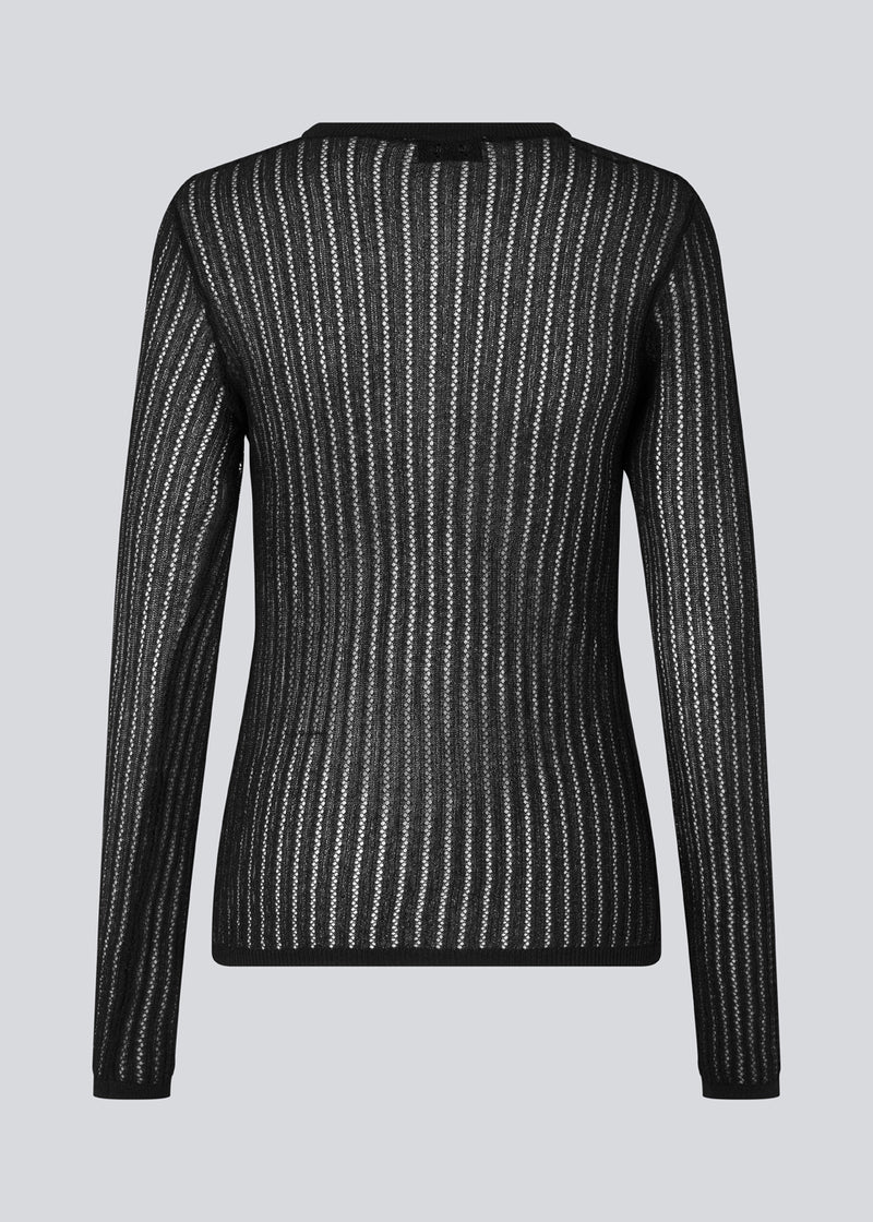 Fitted black top in an airy knit with a closer ribknitted front with a sweetheart neckline. FaddieMD o-neck has a round neck and long sleeves. The model is 175 cm and wears a size S/36.