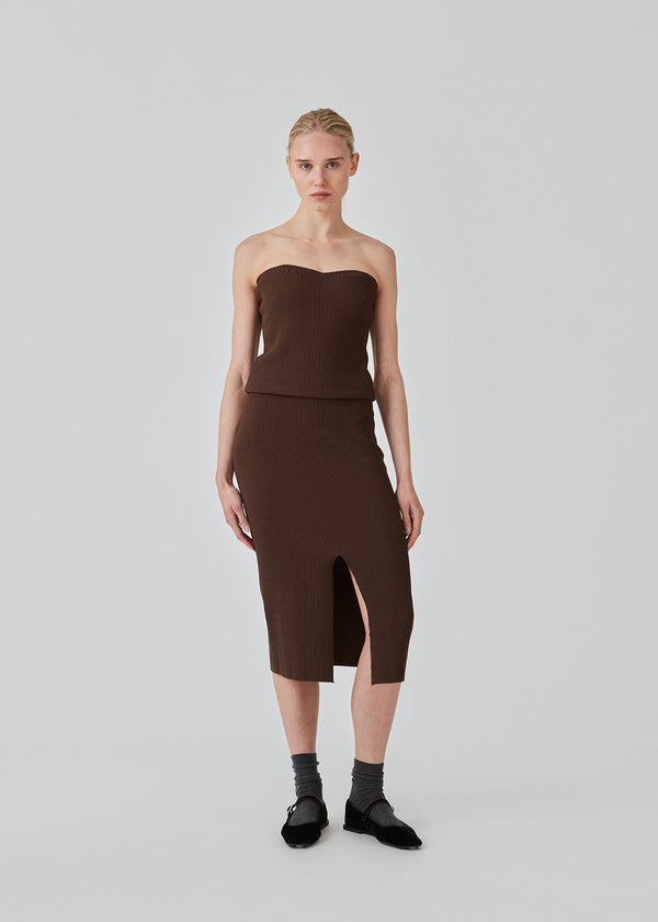 Tight fitted midi skirt in a soft, ribbed material. FainaMD skirt is designed with a high waist with covered elastication, and a high slit in front. Part of matching set. Buy the tube top here. The model is 175 cm and wears a siz