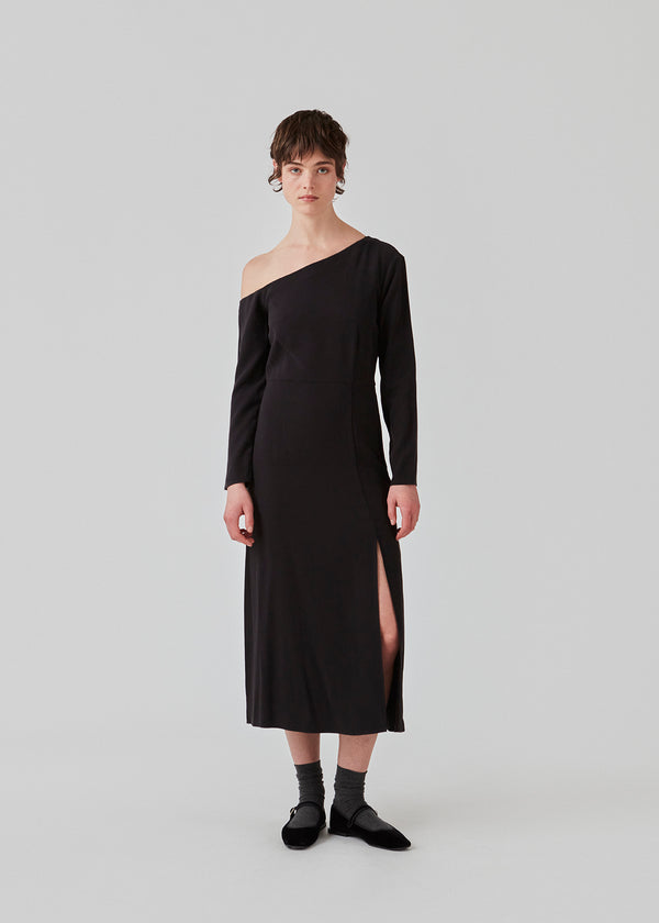 Midi dress designed in an EcoVero viscose quality. FanyaMD long dress has a normal fit with asymmetrical long sleeves with a bare shoulder, cutline at the waist and a slit in front. The model is 175 cm and wears a size S/36.