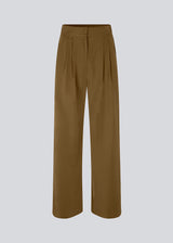 FanyaMD pants in brown have a menswear-inspired look with straight, wide legs, a high waist with zip fly and button and elastication in the back. Double pleat in front and side pockets. The model is 175 cm and wears a size S/36.