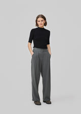 FanyaMD pants have a menswear-inspired look with straight, wide legs, a high waist with zip fly and button and elastication in back. Doubble pleat in front and side pockets. The model is 175 cm and wears a size S/36.