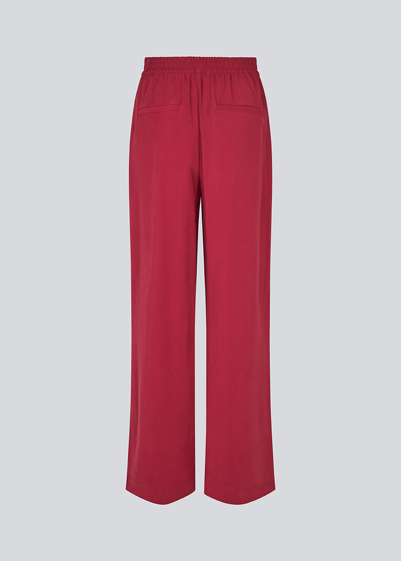 FanyaMD pants have a menswear-inspired look with straight, wide legs, a high waist with zip fly and button and elastication in back. Doubble pleat in front and side pockets. The model is 175 cm and wears a size S/36.