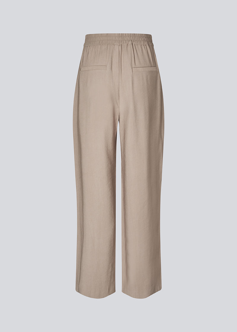 FanyaMD pants have a menswear-inspired look with straight, wide legs, a high waist with zip fly and button and elastication in back. Doubble pleat in front and side pockets. 