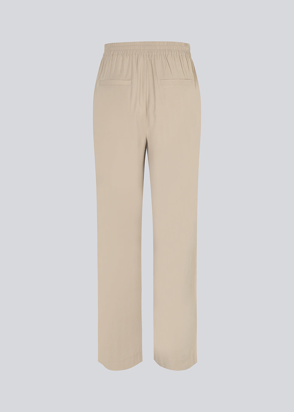 FanyaMD pants in bright beige have a menswear-inspired look with straight, wide legs, a high waist with zip fly and button and elastication in back. Doubble pleat in front and side pockets. The model is 175 cm and wears a size S/36.