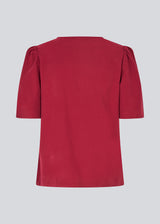 Top with short sleeves and a relaxed fit. FanyaMD SS top has an opening in front with a button closure.