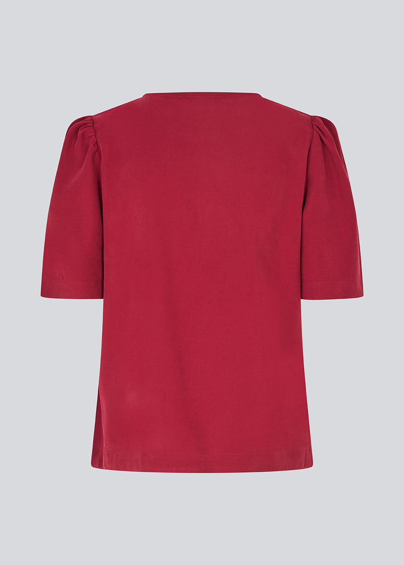 Top with short sleeves and a relaxed fit. FanyaMD SS top has an opening in front with a button closure.