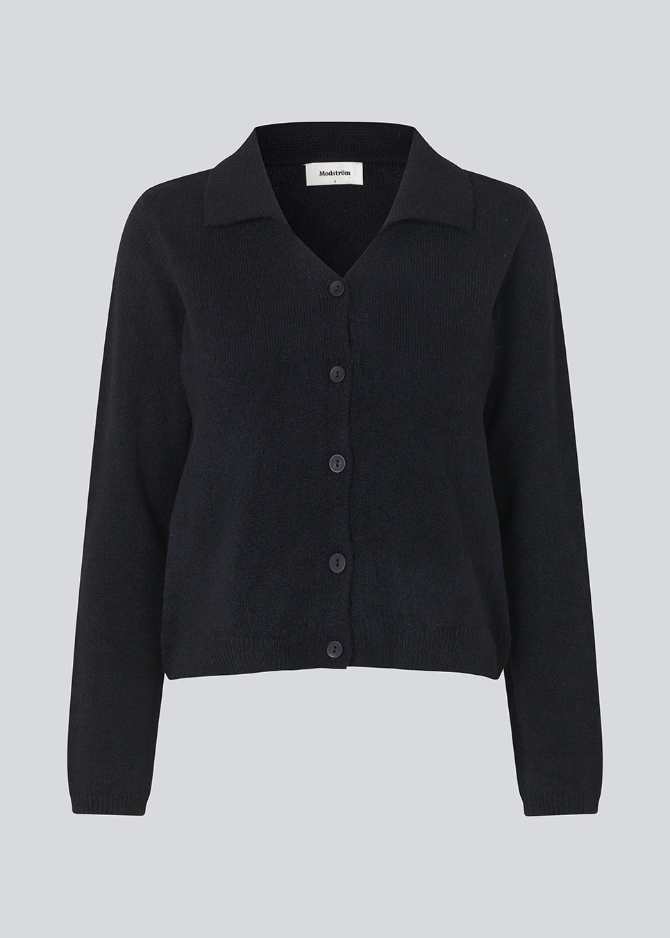 Fine knit cardigan in navy blue with a v-neckline and collar. FaroMD cardigan has a relaxed shape with matching buttons in front and ribbed trimmings. The model is 175 cm and wears a size S/36.