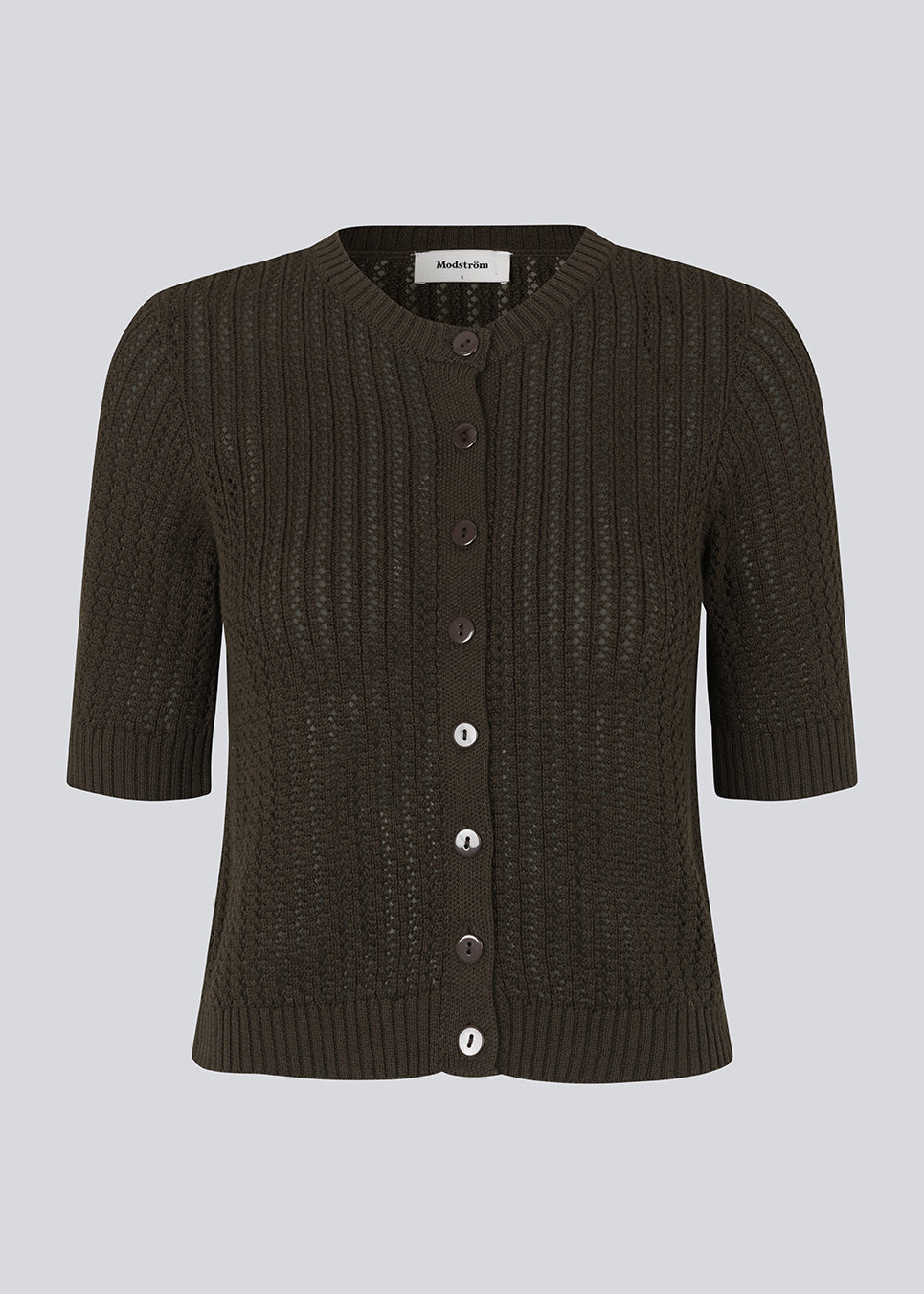 Short-sleeved cardigan knitted from organic cotton with an eyelet pattern. FaxonMD cardigan features a round neck with buttons in front. The model is 175 cm and wears a size S/36.