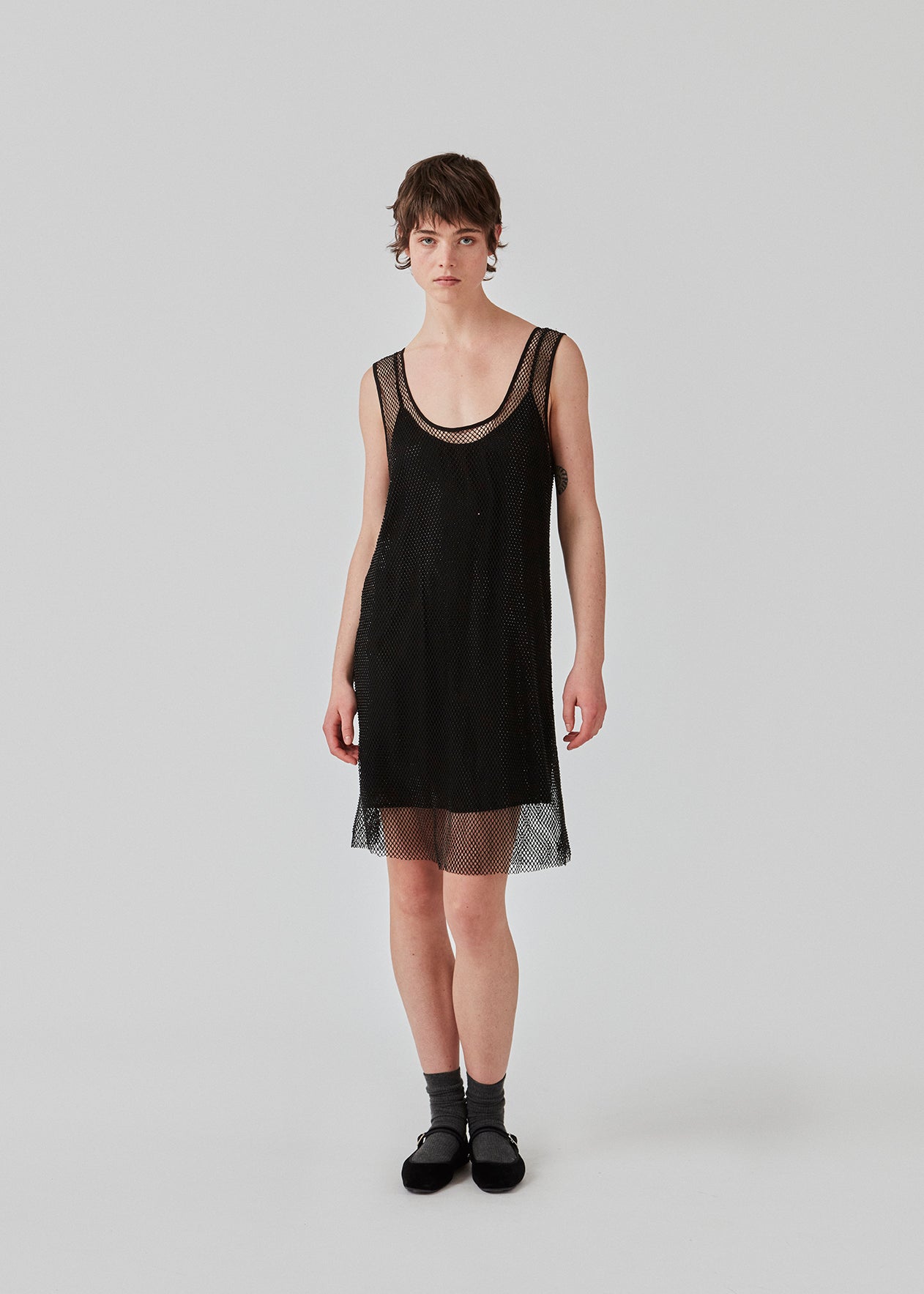 Short dress with a straight silhouette and wide straps. FazilMD dress has a see-through overlay with shiny pearls and a slip dress with a v-neckline. The model is 175 cm and wears a size S/36.