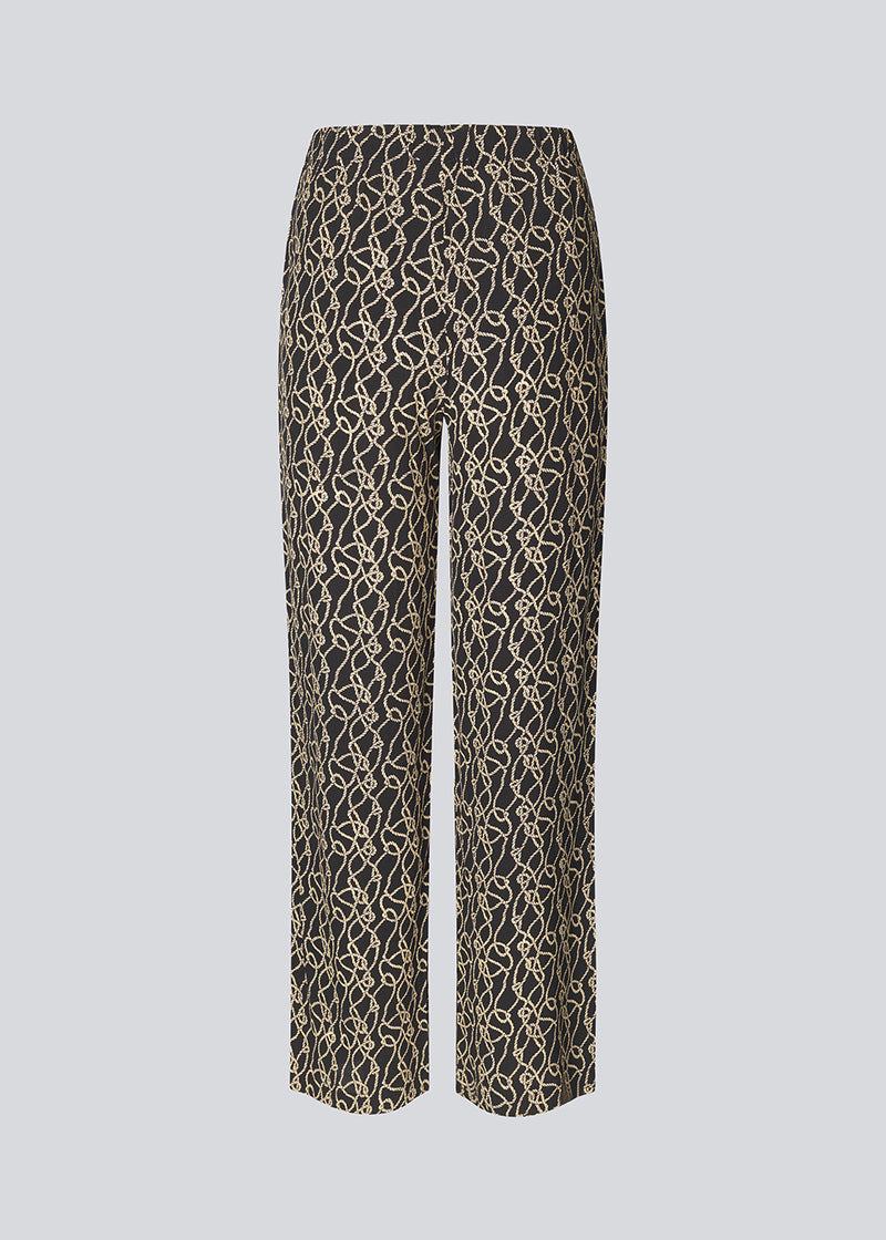 Printed pants in EcoVero viscose with a medium waist and straight, wide legs. Zip fly and button in front and covered elastic in the back waist. The model is 175 cm and wears a size S/36.
