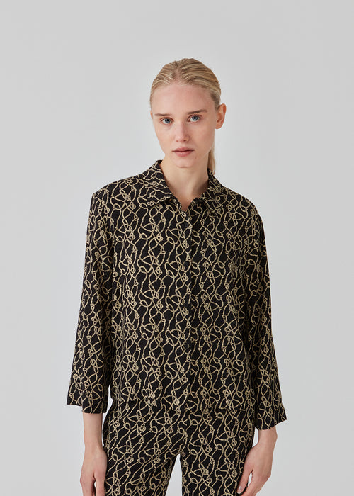 Short shirt in a woven EcoVero viscose. FelineMD print shirt has a collar, buttons in front and 3/4 length sleeves with volume. The model is 175 cm and wears a size S/36.