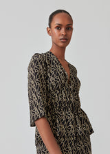 Feminine top with a deep v-neckline with ruffled details at the waist in front and back with fringe. FelineMD print top has short puff sleeves. The model is 175 cm and wears a size S/36.