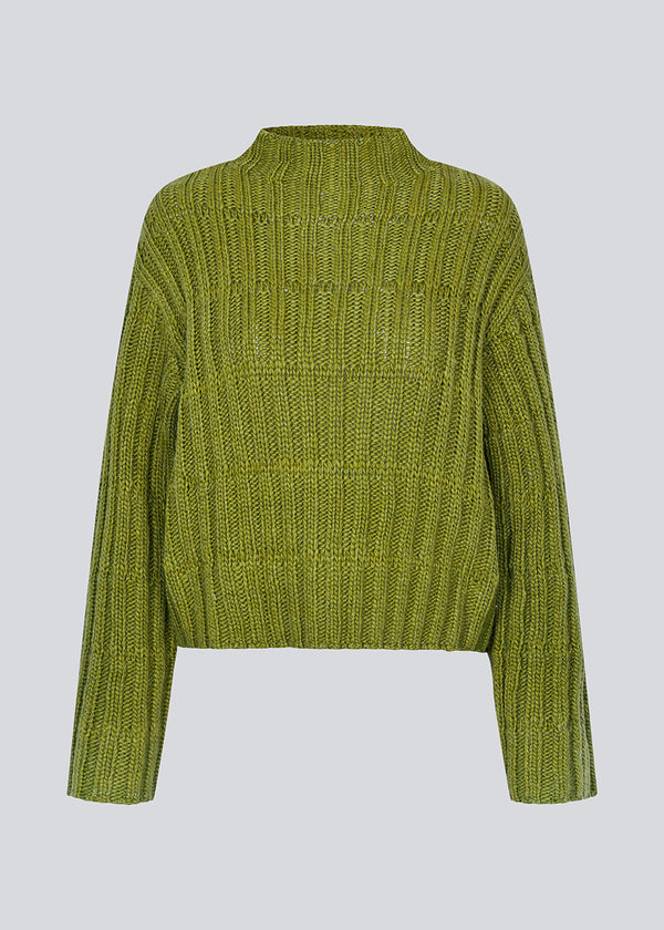 Green knit with dropped shoulders and long wide sleeves. FelipeMD t-neck has a high neck with ribbed trimmings on the neckline and hem of sleeves.