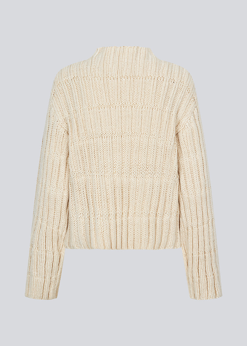 Off white knit with dropped shoulders and long wide sleeves. FelipeMD t-neck has a high neck with ribbed trimmings on the neckline and hem of sleeves.&nbsp;