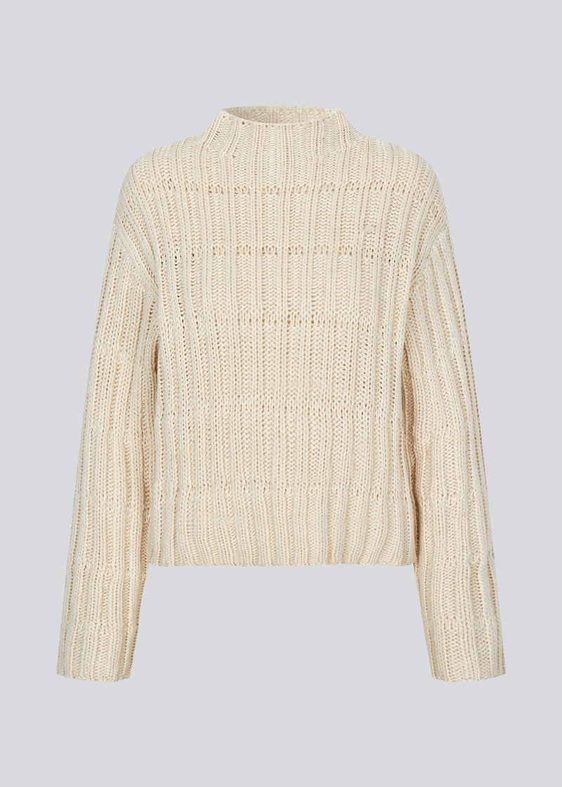 Off white knit with dropped shoulders and long wide sleeves. FelipeMD t-neck has a high neck with ribbed trimmings on the neckline and hem of sleeves.&nbsp;