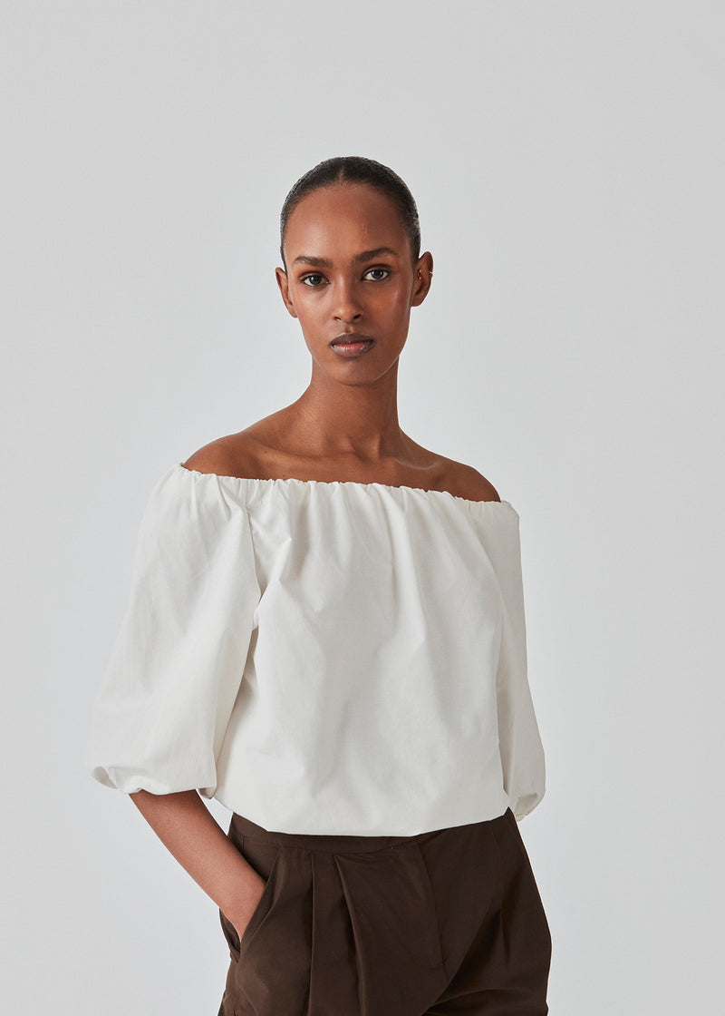 Off shoulder top in white in a woven cotton quality. Elastication at neckline and sleeves. FernandoMD top has a slightly oversized fit. The model is 175 cm and wears a size S/36.