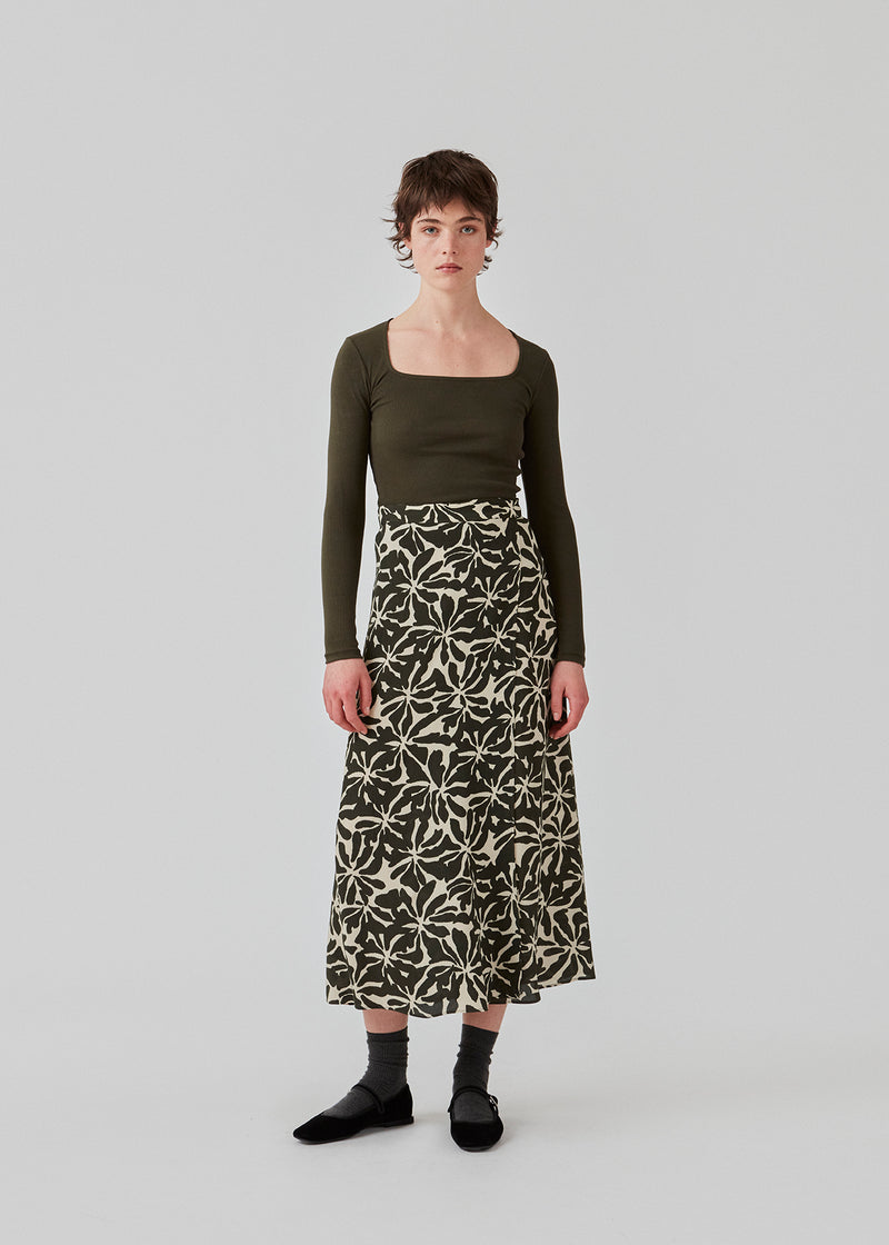 Midi dress in a light woven EcoVero viscose quality with a slit in front. FernMD print skirt has a high waist with covered elastication at the back. The model is 175 cm and wears a size S/36.