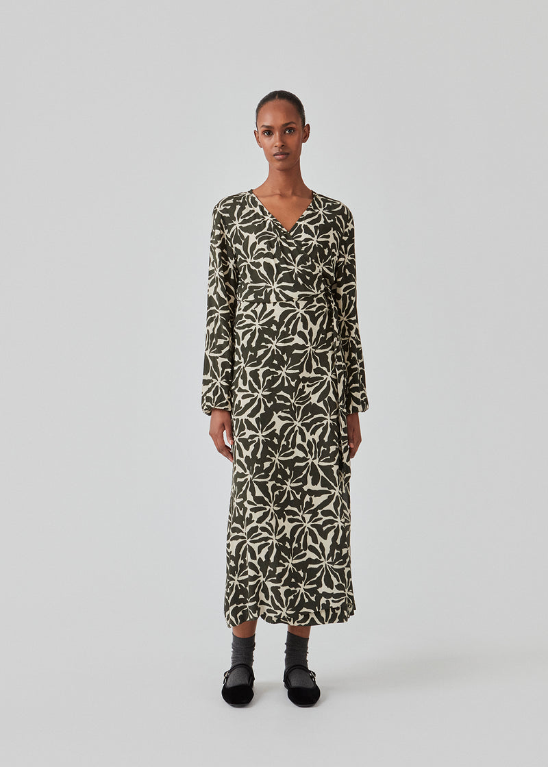Midi dress in printed EcoVero viscose with v-neckline and wrap detail in front. FernMD print wrap dress has a wide tie belt at the waist and long balloon sleeves. The model is 175 cm and wears a size S/36.