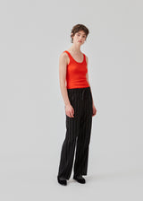 FiaMD pants have a loose fit in a linen mix with vertical stripes. The pants have an elasticated waist with tiebelt and side pockets. 