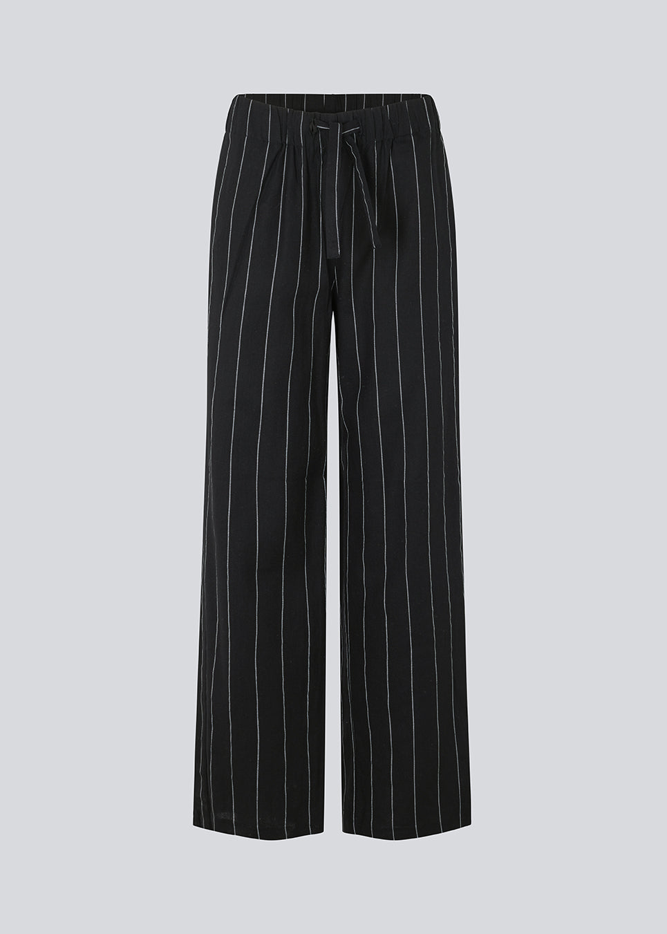 FiaMD pants in bkack have a loose fit in a linen mix with vertical stripes. The pants have an elasticated waist with tiebelt and side pockets. The model is 177 cm and wears a size S/36.