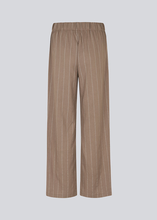 FiaMD pants have a loose fit in a linen mix with vertical stripes. The pants have an elasticated waist with tiebelt and side pockets. 