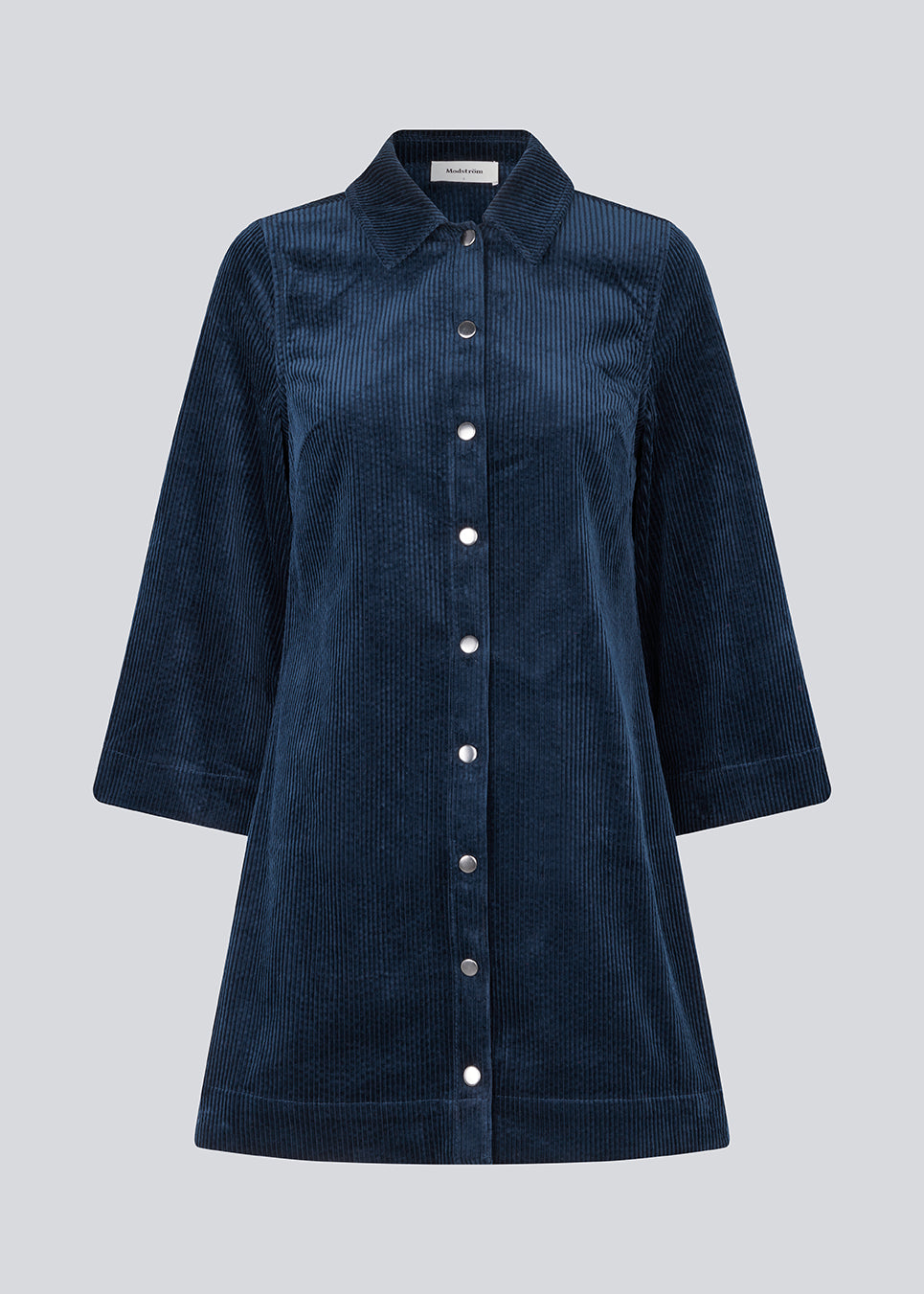 Midi shirt dress in navy sky in corduroy with collar and press-studs in front. FikaMD dress has a loose A-line silhouette and 3/4 length wide sleeves. The model is 175 cm and wears a size S/36.