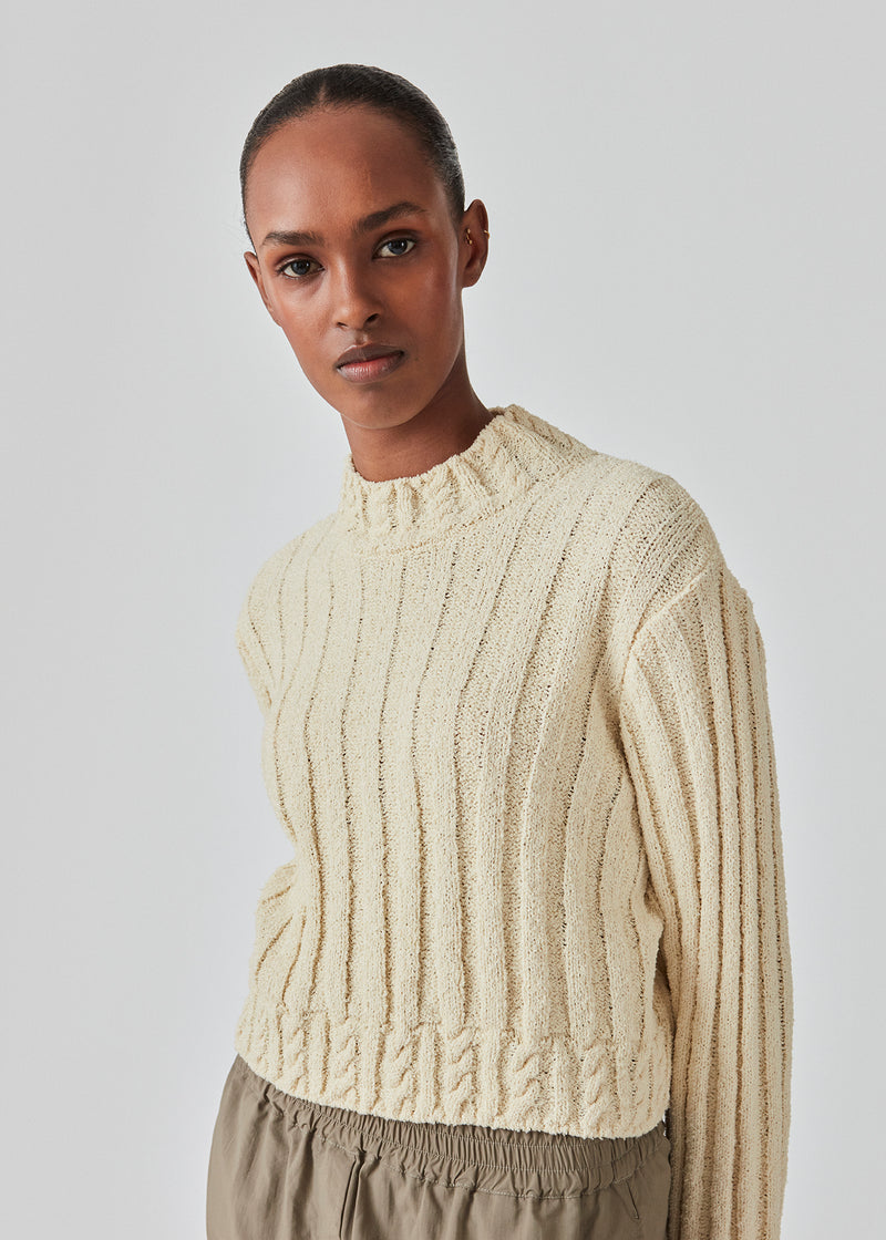 Short cable knit top in cotton mix. FinaMD o-neck has a relaxed silhouette with long sleeves and a high neck. The model is 175 cm and wears a size S/36.