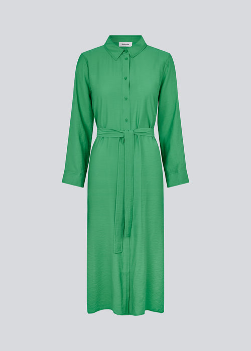 Midi dress in green in woven quality with collar, buttons in front, detachable tie belt at the waist and a slit at each side. Long sleeves with cuff. The model is 175 cm and wears a size S/36.
